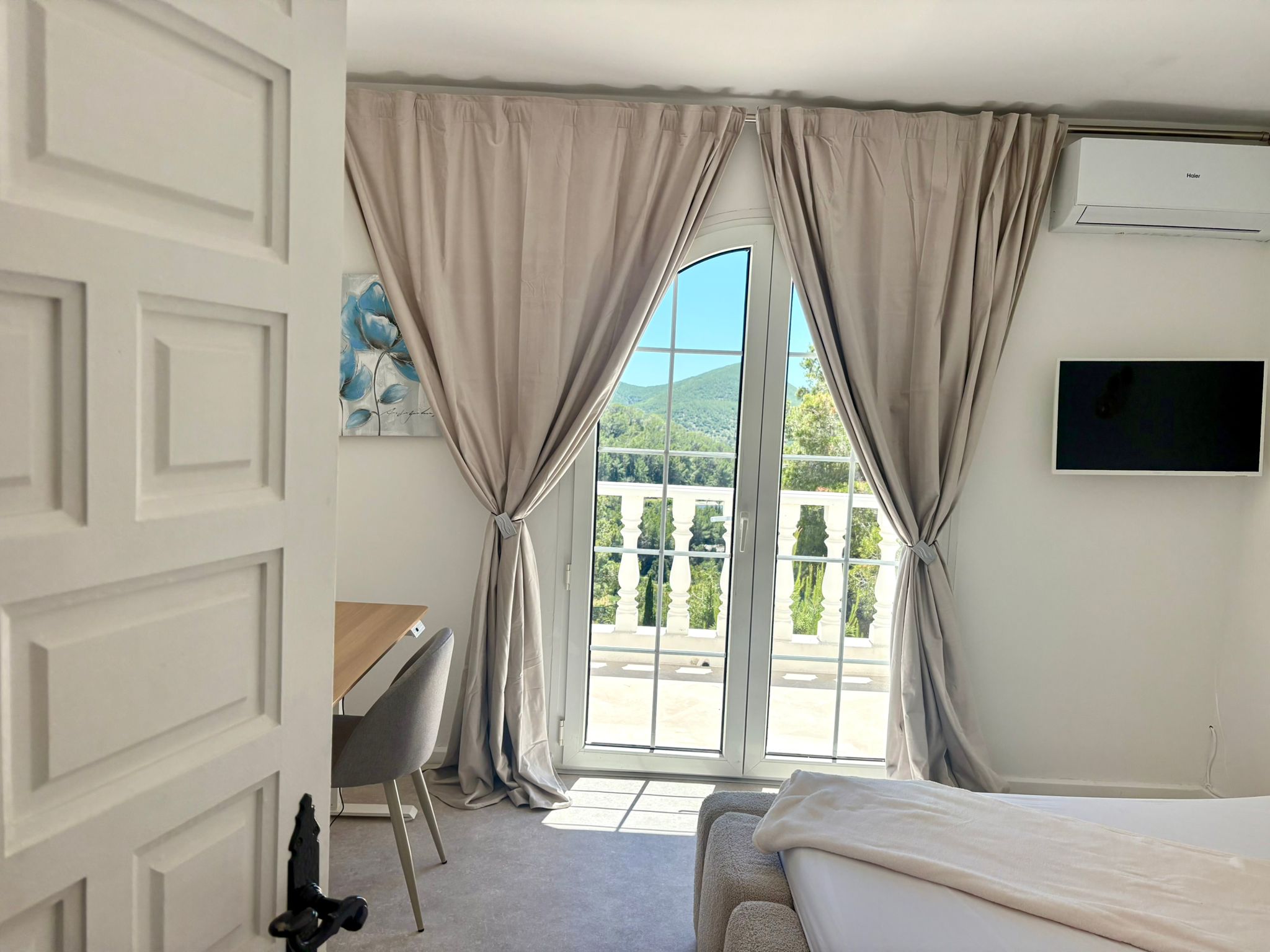 Schlafzimmer mit Schreibtisch und Balkon