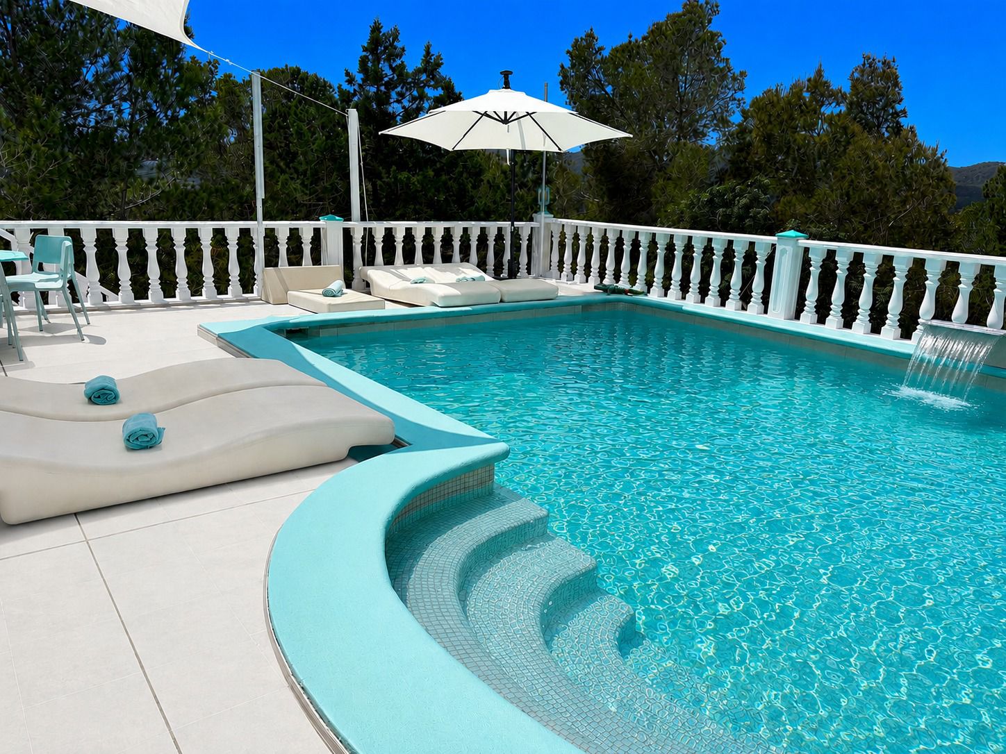 Pool mit Wasserfall und Sonnenliegen